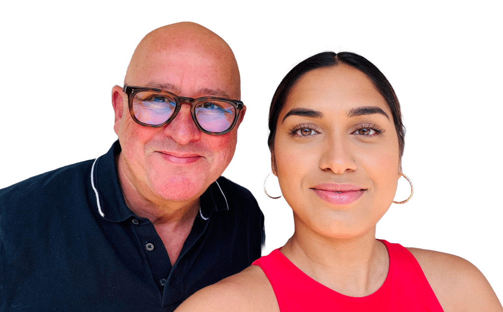 A man and a woman smiling in a close-up selfie. The man has a bald head and glasses, wearing a dark polo shirt. The woman has long hair tied back and is wearing a red top.